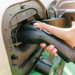 dziewczyna ładuje swój samochód elektryczny na stacji ładowania Przyjazne dla środowiska źródła energii