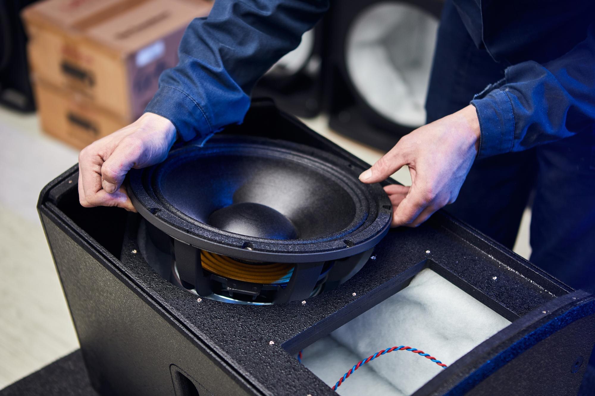 Pracownik produkuje głośniki i głośniki w fabryce Ręcznie tworzone akustyczne systemy muzyczne