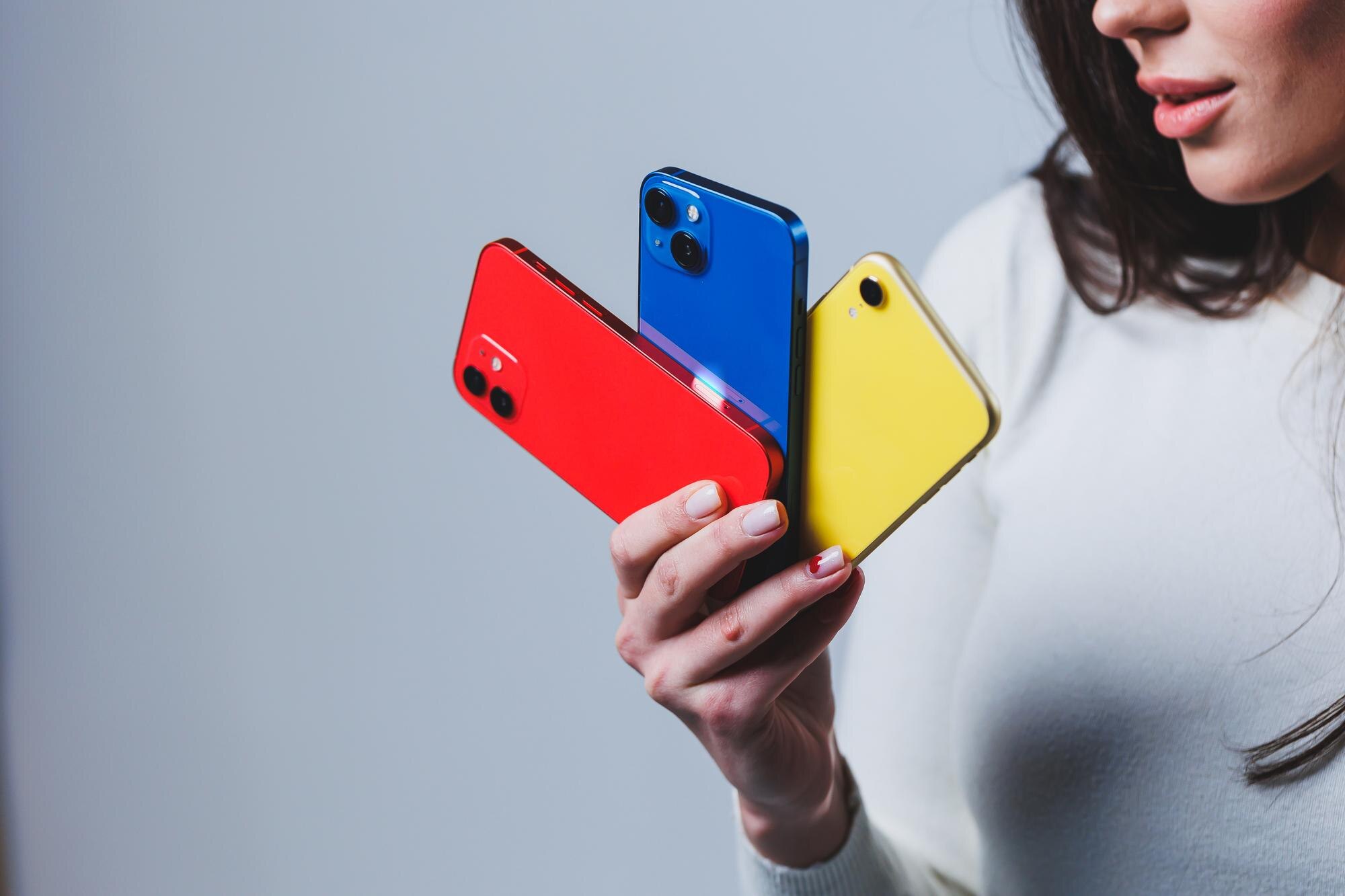 Nowe jasne telefony w rękach kobiety Ręce kobiety trzymającej kilka smartfonów