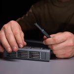 Osoba demonstrująca precyzję za pomocą narzędzi naprawiających skomplikowane elementy elektroniczne