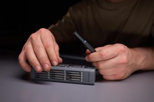 Osoba demonstrująca precyzję za pomocą narzędzi naprawiających skomplikowane elementy elektroniczne