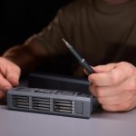 Osoba demonstrująca precyzję za pomocą narzędzi naprawiających skomplikowane elementy elektroniczne