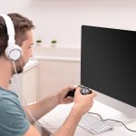 Młody mężczyzna grający w gry komputerowe w domu