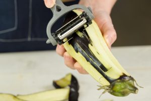 Bakłażan w kobiecych rękach obierania bakłażana nożem