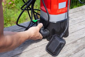 Na drewnianym stole znajduje się regulowana pompa wody