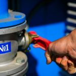 Męska ręka otwiera kurek gazu nr 1