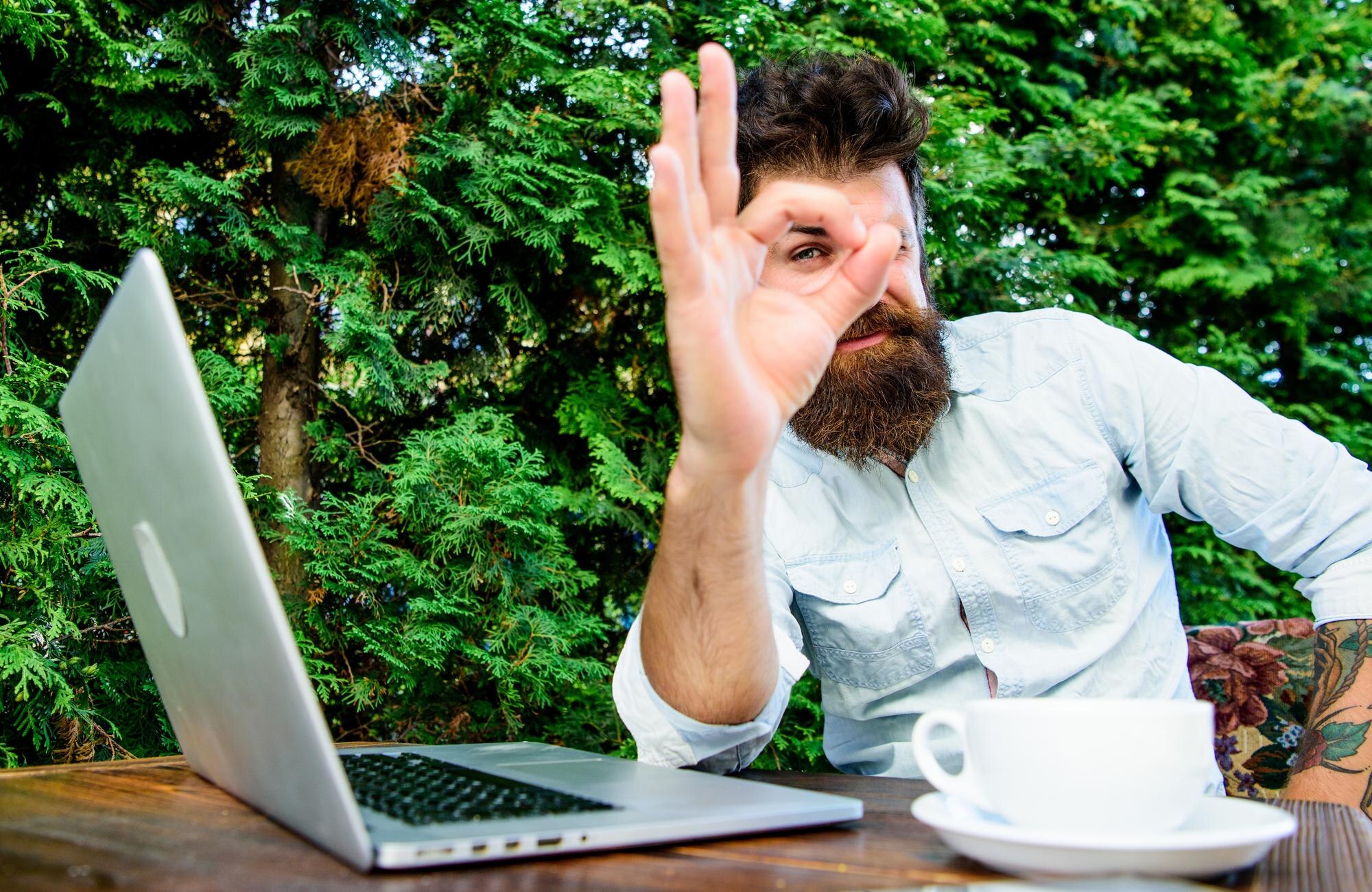 Dobra robota Hipster zajęty freelancerem Wifi i laptop Pij kawę i pracuj szybciej Brodaty mężczyzna odnoszący sukcesy freelancer Praca zdalna Freelancer Zawód zawodowy Zadowolony z rezultatu