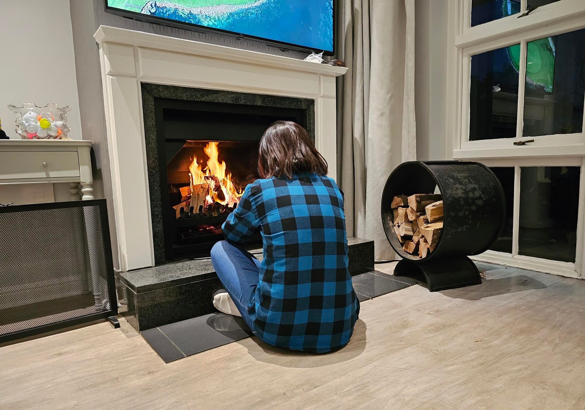 Młoda, piękna, zrelaksowana, atrakcyjna kobieta przy kominku.