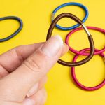 Wielokolorowe gumki do włosów na żółtym tle