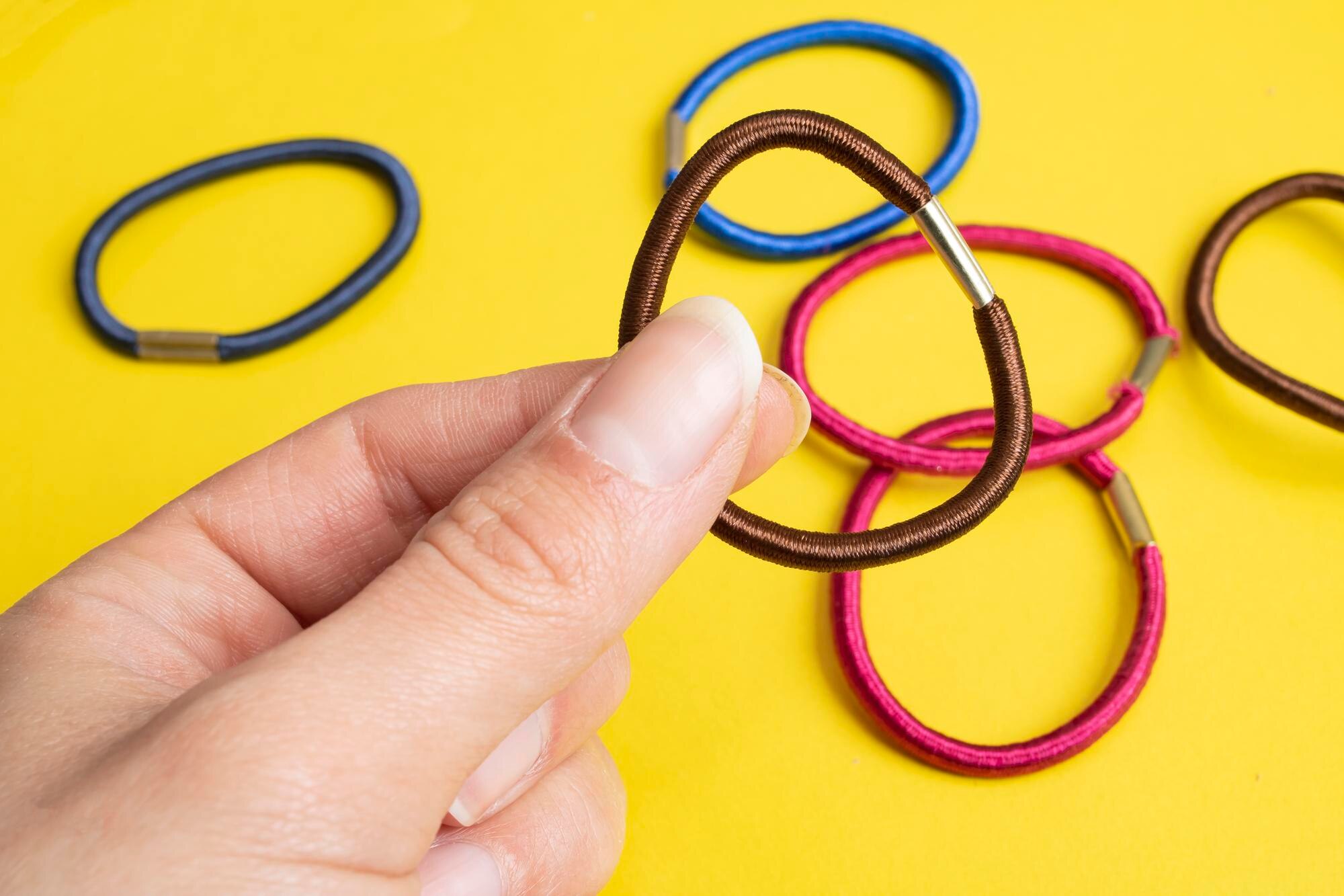 Wielokolorowe gumki do włosów na żółtym tle