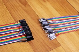 Zestaw wielokolorowych przewodów na drewnianym tle