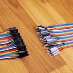 Zestaw wielokolorowych przewodów na drewnianym tle