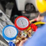 Mechanik trzymający narzędzie do monitorowania, aby sprawdzić i naprawić układ klimatyzacji samochodowej Technik sprawdza układ klimatyzacji samochodowej ładowanie czynnika chłodniczego Naprawa klimatyzacji