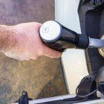 Ręka mężczyzny tankującego wężem w baku samochodu