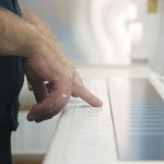 Pracownik przemysłowy za pomocą panelu sterowania maszyny drukarskiej