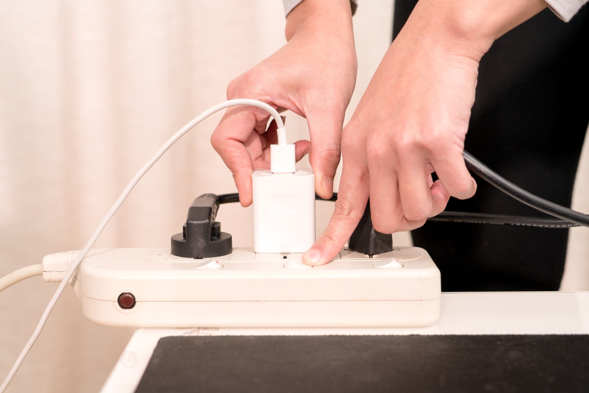 Kobiety ręka stawia elektryczną prymkę podczas włączać onelectricity źródło zasilania