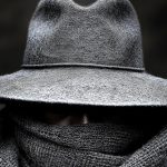 Mężczyzna w szarym kapeluszu i chustce