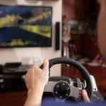 Człowiek gra wyścigowy z symulatorem kierownicy