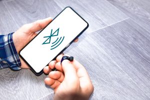 Mężczyzna łączący słuchawki bezprzewodowe z telefonem komórkowym