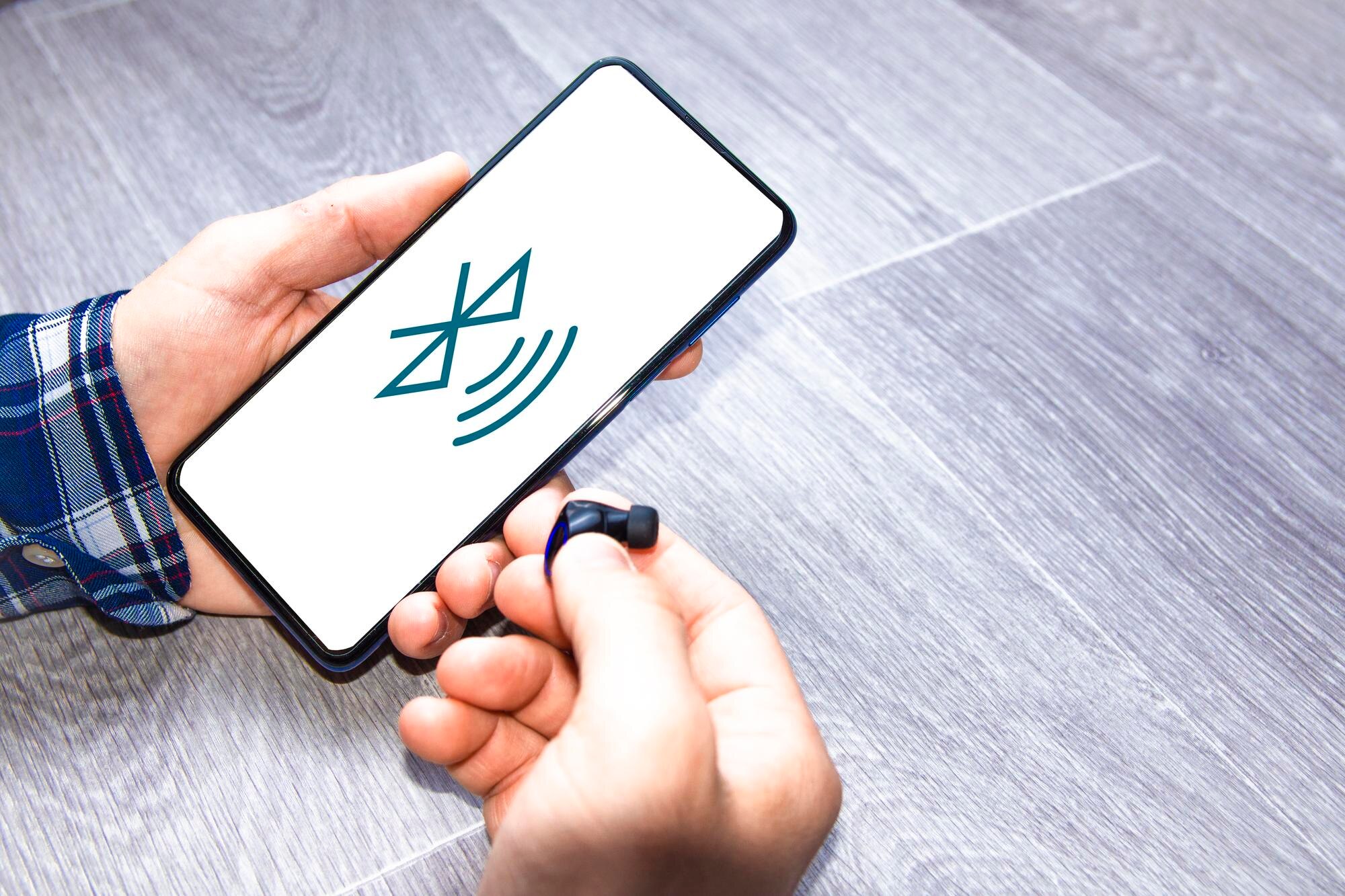 Mężczyzna łączący słuchawki bezprzewodowe z telefonem komórkowym