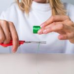 ręka z nożyczkami wycinanie nici, krawcowa, atelier, szycie, szycie ubrań, haftowanie