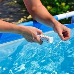 Sprawdzanie jakości wody w basenie za pomocą paska testowego z wartością ph chloru i algicydów
