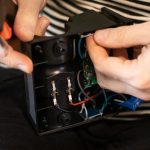 Zbliżenie męskich rąk, naprawiając ładowarkę. Praca z urządzeniami elektronicznymi