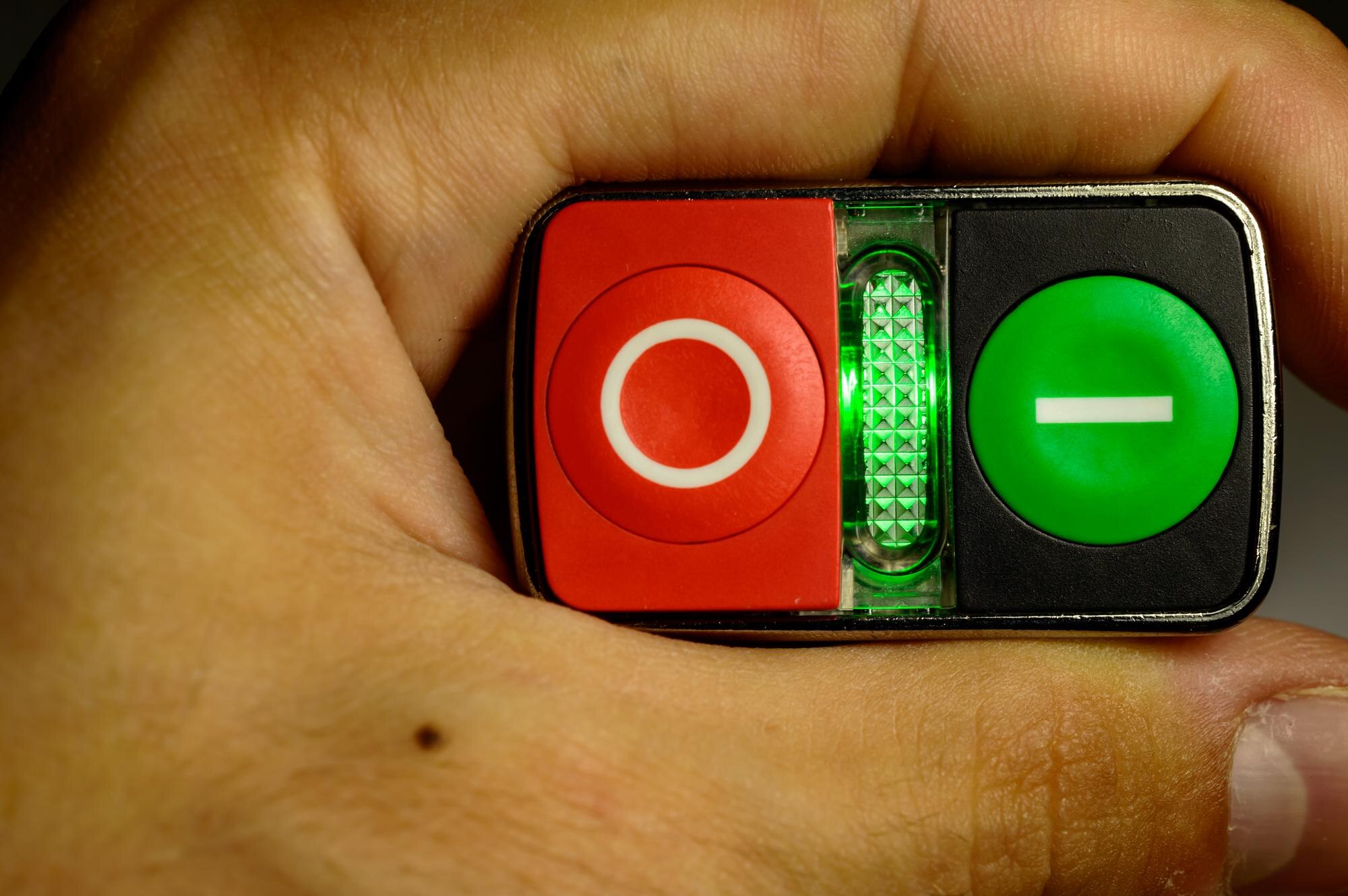 Dziecko trzymające w ręku mały starter. Czerwone i zielone przyciski do uruchamiania silnika.