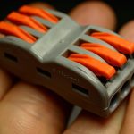 Zacisk elektryczny do szybkiego podłączenia przewodów na dłoni dziecka - zdjęcie w zbliżeniu.