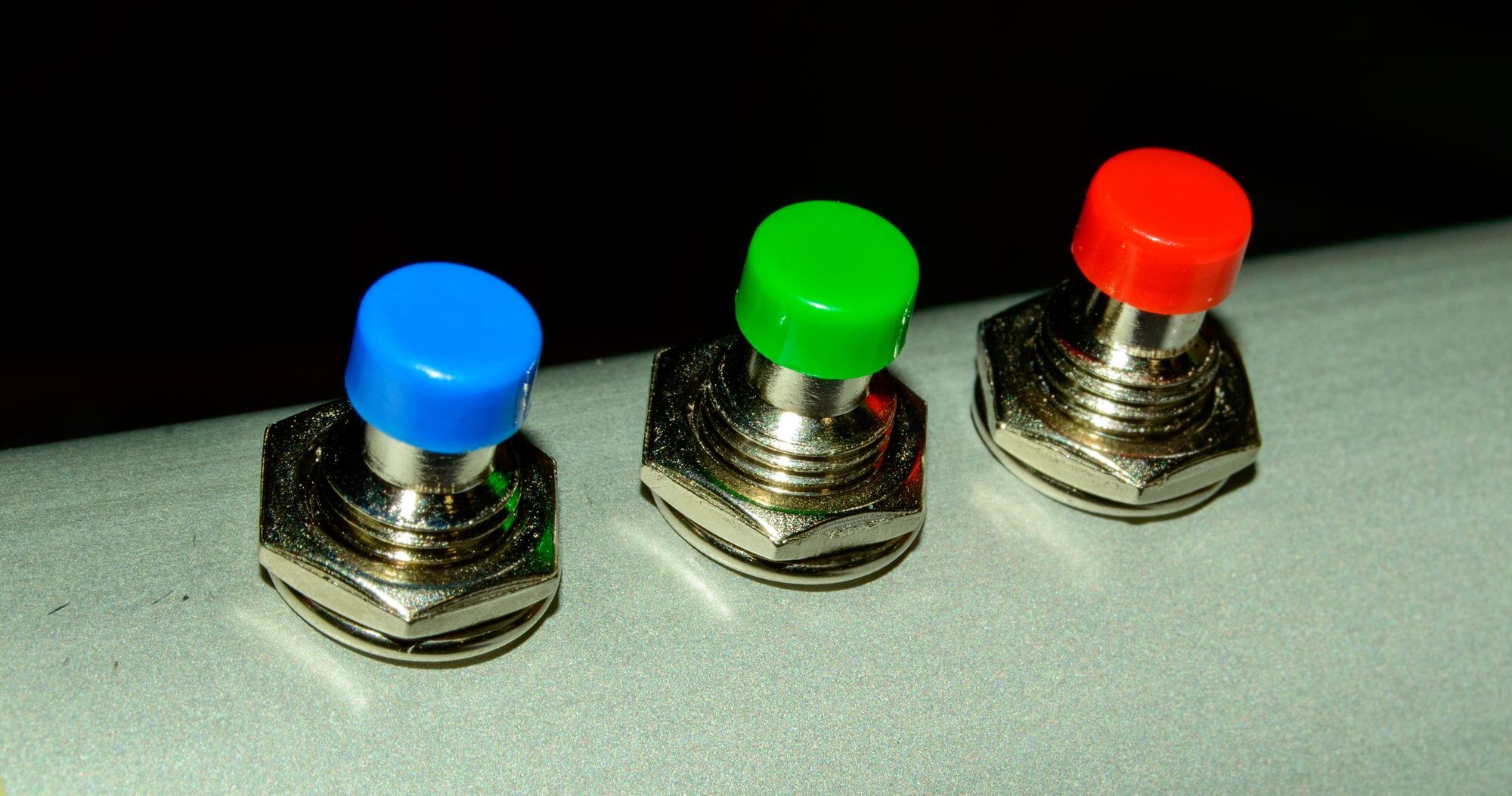 Małe kolorowe guziki na aluminiowej rurce - zbliżenie na zdjęcie. Obraz w tle.