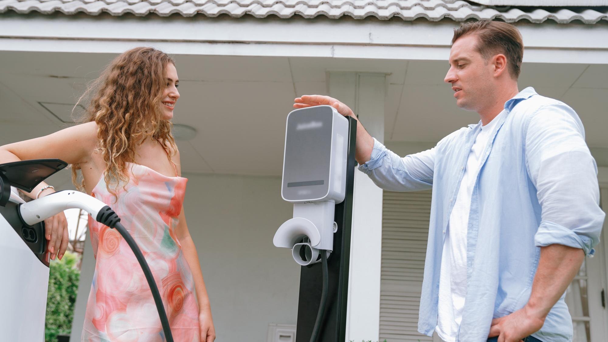 Szczęśliwa para ładuje pojazd elektryczny ze stacji ładowania Synchronos