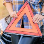 Kobieta trzyma w dłoniach znak stopu awaryjnego