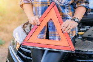 Kobieta trzyma w dłoniach znak stopu awaryjnego