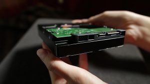 Dysk twardy z bliska zbiory Kobiece dłonie pokazujące spód dysku hdd