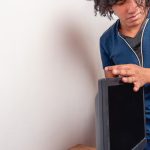 Młoda brunetka w pokoju instaluje monitor komputerowy