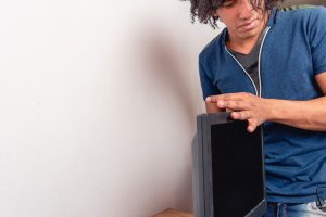 Młoda brunetka w pokoju instaluje monitor komputerowy