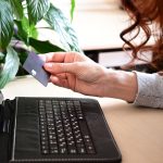 Ręce trzymające kartę kredytową i korzystające z laptopa Zakupy online