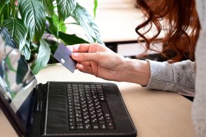 Ręce trzymające kartę kredytową i korzystające z laptopa Zakupy online
