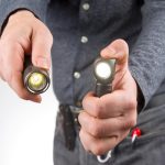 Mężczyzna trzyma latarkę w ręku przedmiot do biwakowania i życia domowego