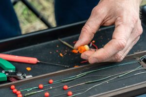 Zbliżenie na zdjęcie męskiej ręki ze sprzętem wędkarskim