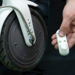 Naprawa nowoczesnej hulajnogi elektrycznej w profesjonalnym warsztacie W rękach mechanika narzędzie i zdemontowane części hulajnogi są w rękach Zbliżenie koła i opony