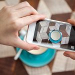 Blogger robi zdjęcia kawy na stole w kawiarni