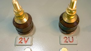 Zbliżenie zaworów maszyn przemysłowych do panelu sterowania regulacją napięcia z nakrętkami śrubowymi