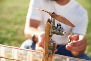 Z drewna Człowiek jest na polu naprawiający samolot zabawki