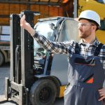 Portret profesjonalnego kierowcy wózka widłowego w magazynie fabryki