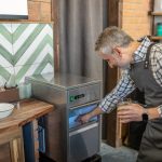 Lód na sok. Mężczyzna w kraciastej koszuli bierze lód z lodówki