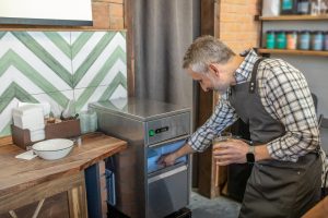 Lód na sok. Mężczyzna w kraciastej koszuli bierze lód z lodówki