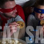 Słowa Stay Safe napisane nad kaukaskim mężczyzną i dziewczyną w pelerynach, jedzące ciasteczka. Pandemia koronawirusa zdrowia publicznego Covid 19 dystans społeczny i samoizolacja w koncepcji blokady kwarantanny