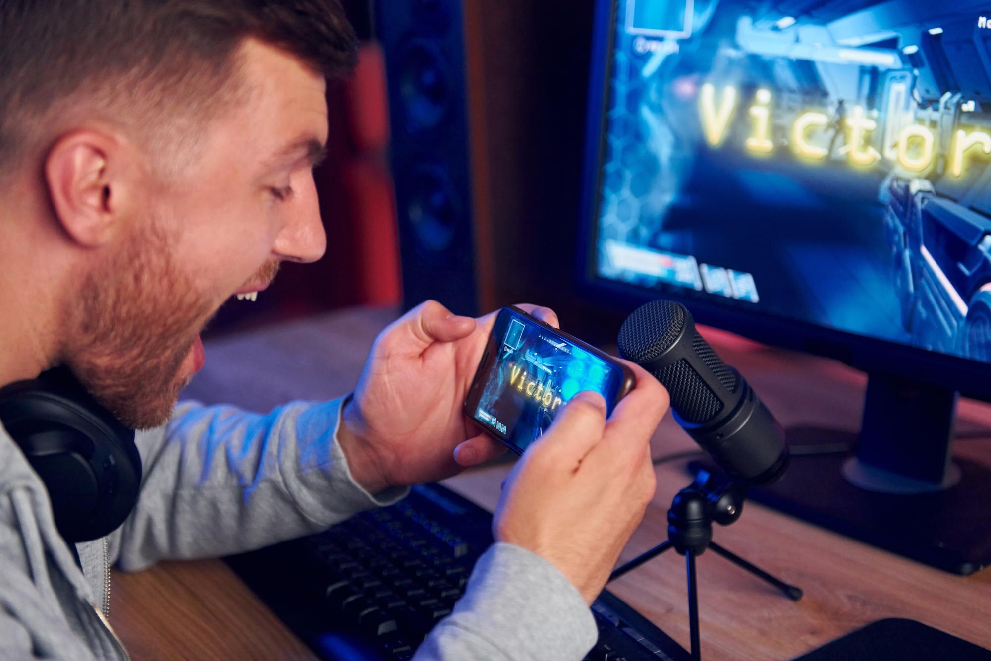 Wyświetlanie monitora i smartfona Streamer online grający w strzelankę FPS w domu