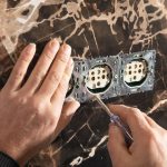 Elektryk instalujący gniazdko ścienne w domu